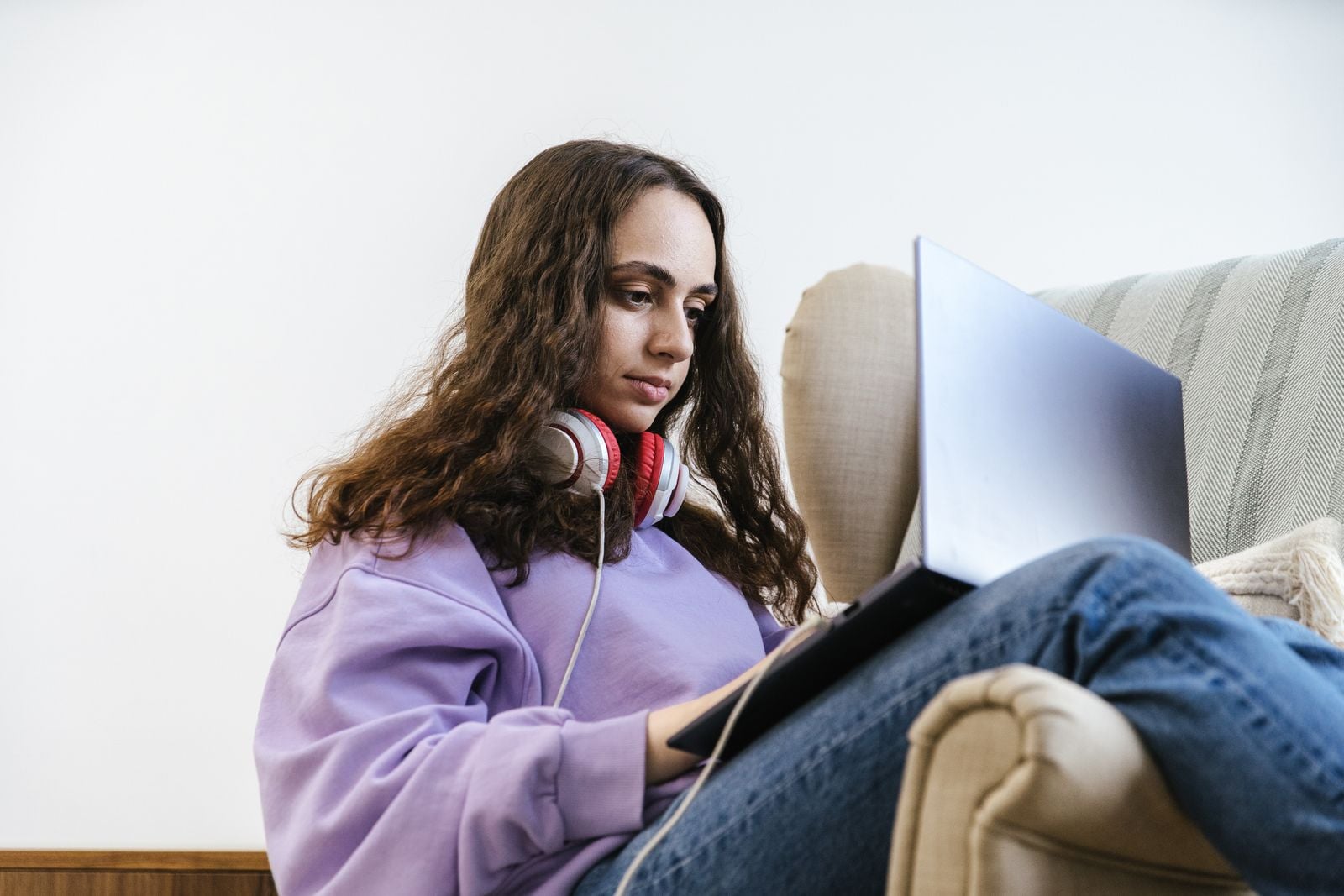 Adolescente con audífonos estudiando en su laptop